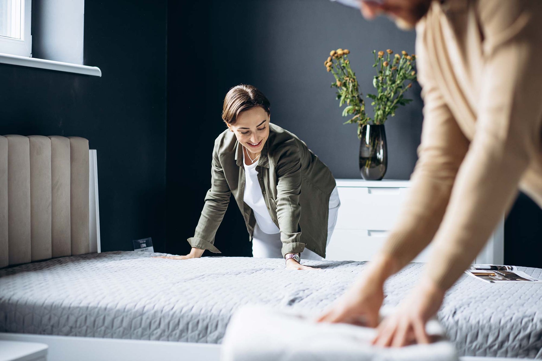 Two Women Making Separate Beds. Mattress Cover on Bed