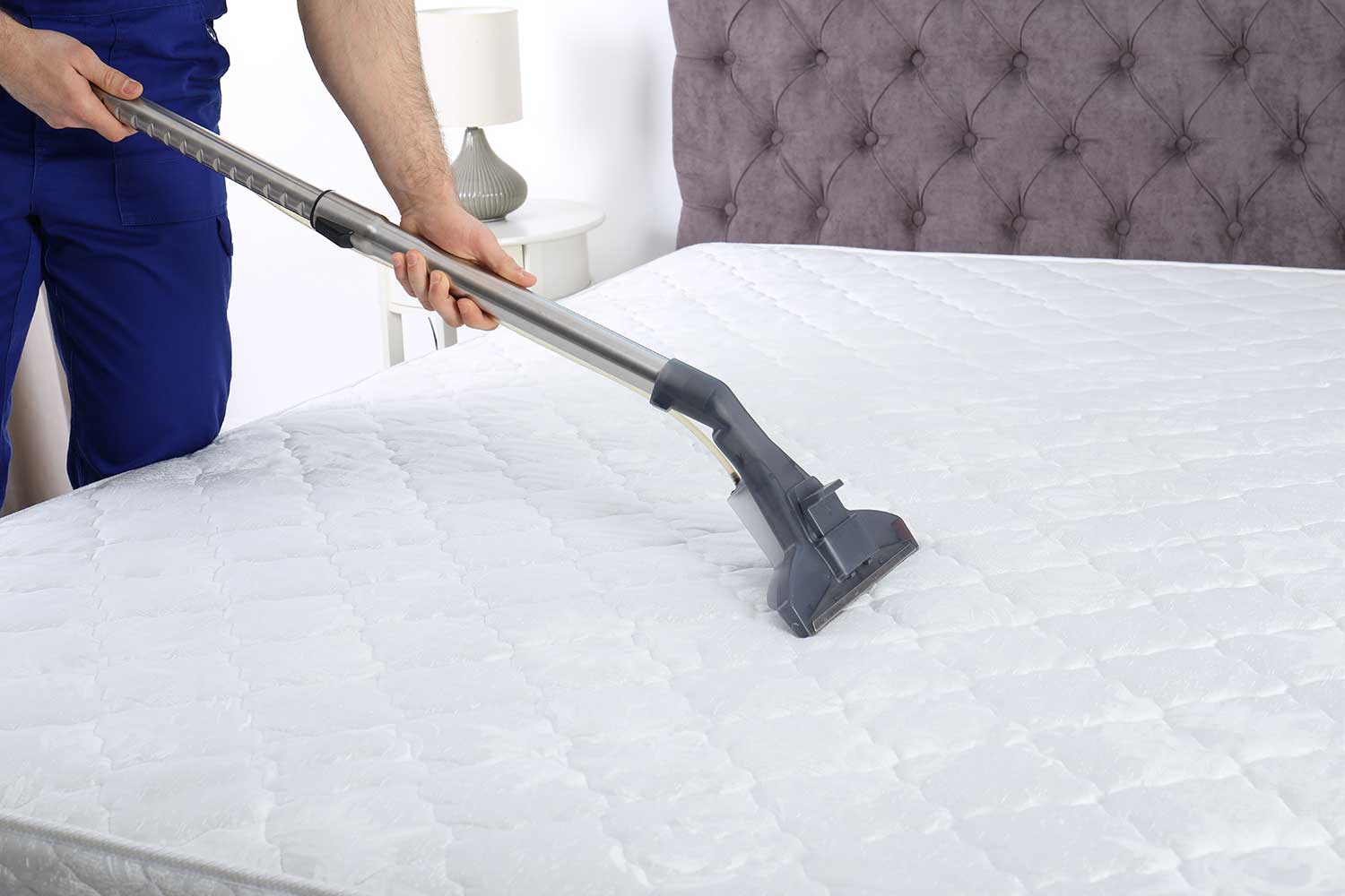 Person Hoovering Bare Mattress