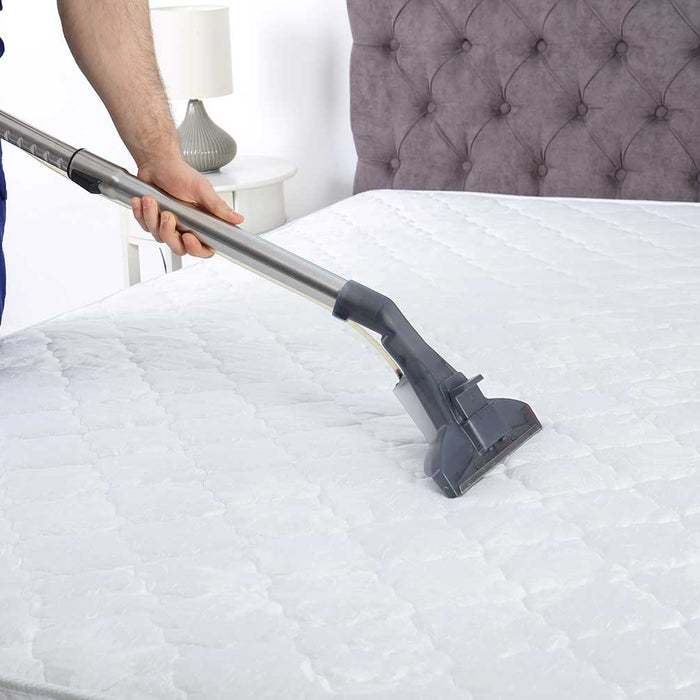 Person Hoovering Bare Mattress