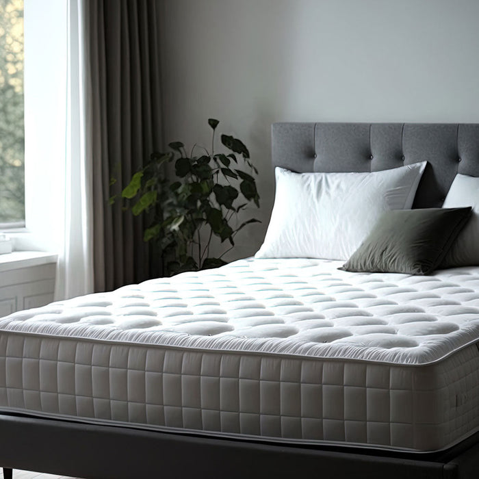 Partially Bare Mattress with Pillows in Large Bedroom. Light Shining from Large Window onto bed