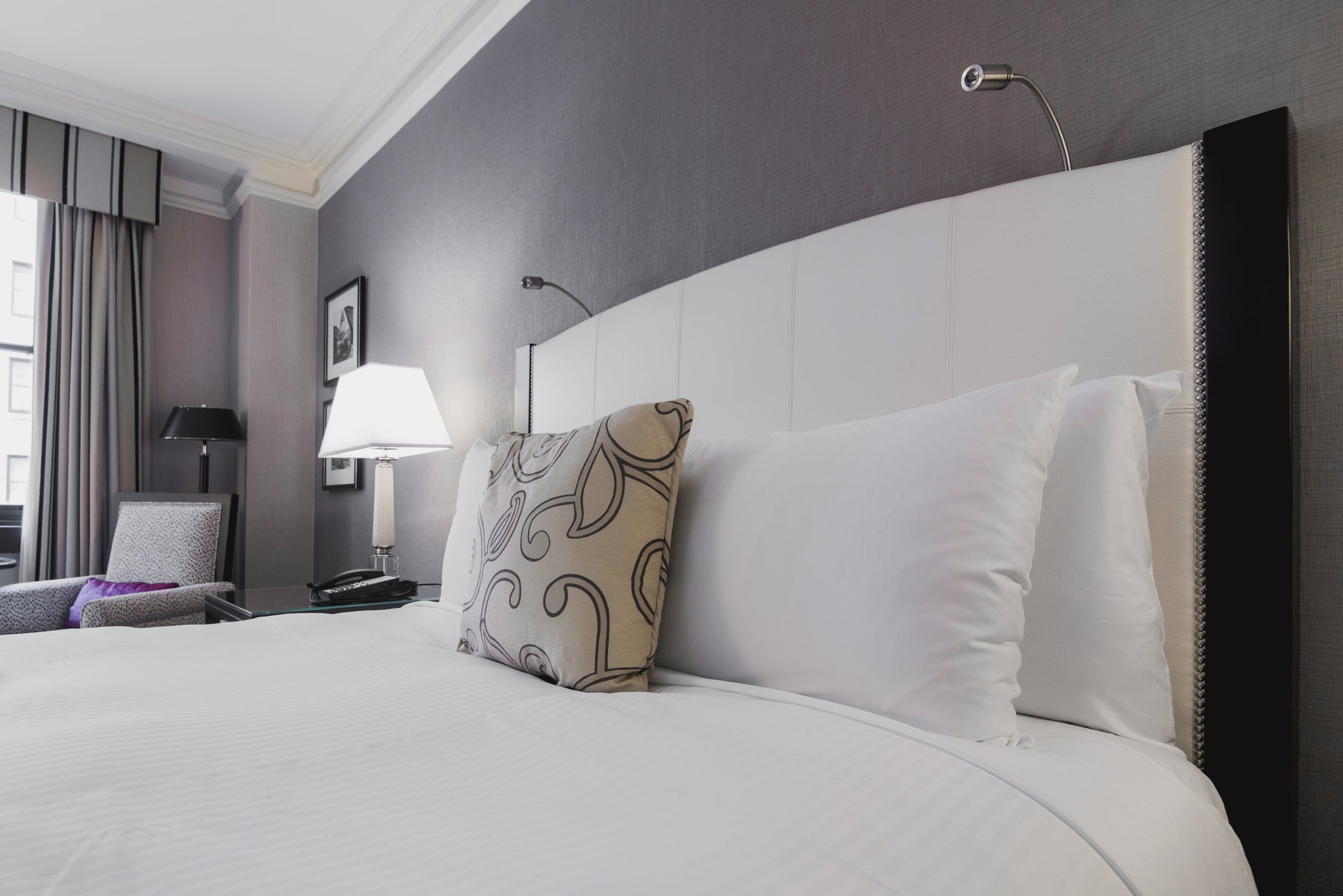 An image of a bed with mattress, bedding and pillows on top.