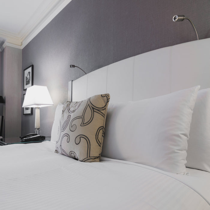 An image of a bed with mattress, bedding and pillows on top.