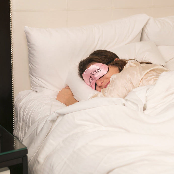 Woman Sleeping with Pink Sleep Mask, Large Comfy Bed in Neutral Coloured Room